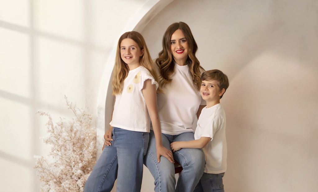 Mujer con camiseta blanca y vaqueros con hijos en una fotografía de Sesiones Especiales del Día de la Madre 2024 en La Rioja